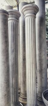 A collection of classical architectural columns with fluted shafts and ornate capitals. The scene evokes the grandeur of Greco Roman design elements. photo