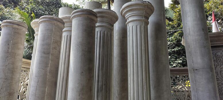 A classical architectural columns with fluted shafts. The vertical lines and aged texture highlight a timeless, ancient aesthetic. photo