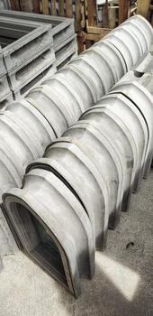 Stacks of molded concrete components arranged neatly in an outdoor industrial area. photo