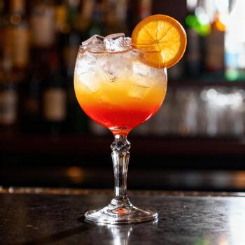 vibrante en capas cóctel adornado con agrios rebanada descansa sobre un oscuro Servicio mostrador foto