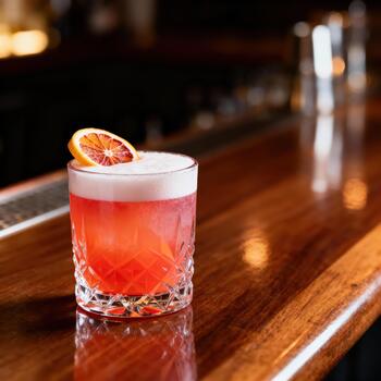 brillantemente de colores cóctel con agrios adornar descansa en un pulido de madera bar parte superior foto