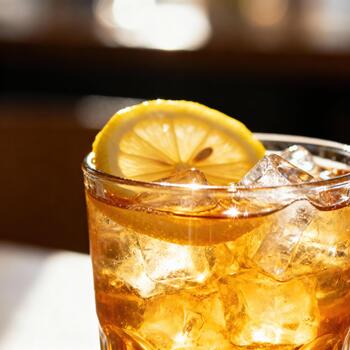 Cold beverage with ice cubes and a bright citrus slice served in a glass photo