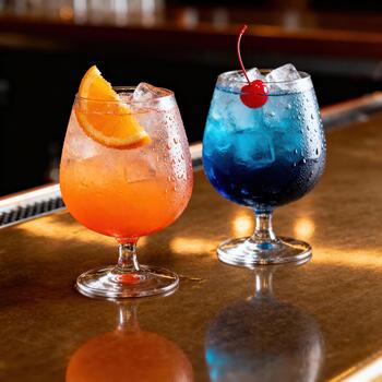 dos enfriado, adornado, vistoso bebidas descanso en un reflexivo bar parte superior superficie foto