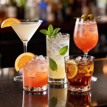 Assortment of refreshing iced cocktails arranged on a reflective bar surface photo