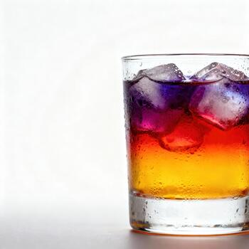 vaso conteniendo en capas brillantemente de colores enfriado bebida con grande hielo cubitos se sienta en contra un blanco antecedentes foto