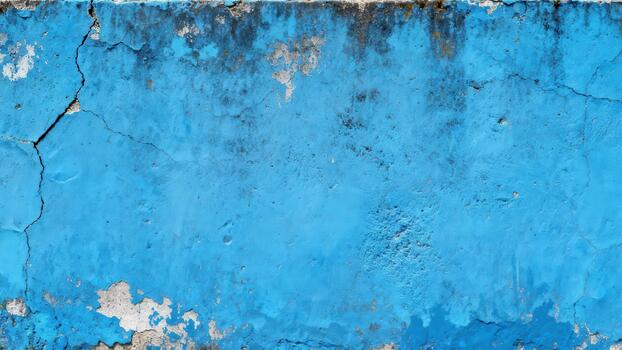 Weathered textured wall surface displays vibrant peeling blue paint and visible cracks photo