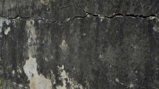 Aged concrete surface displays significant weathered texture and a prominent horizontal fissure photo