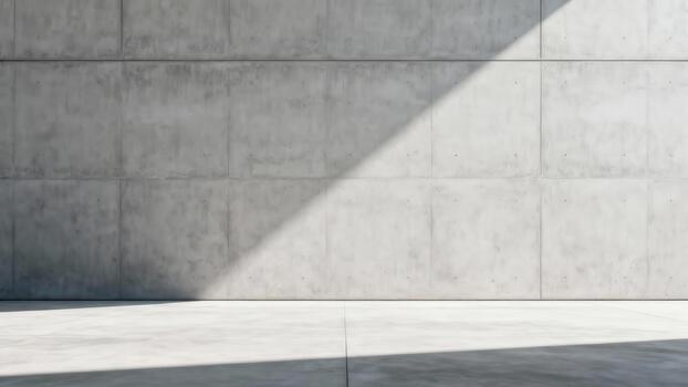 Diagonal sunlight strikes a large, textured concrete wall and floor surface photo