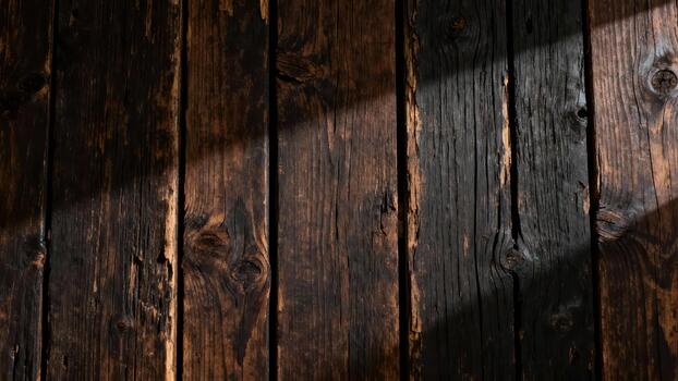 Dark, distressed wooden planks display dramatic diagonal light patterns photo