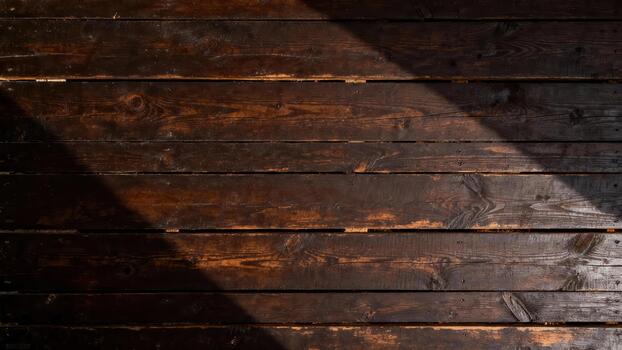 Richly textured dark brown wooden planks display prominent grain patterns illuminated by diagonal daylight. photo