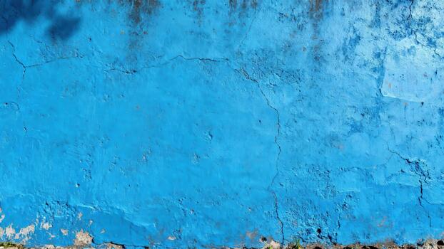 Vivid blue textured surface displays weathering and structural fissures under bright light photo