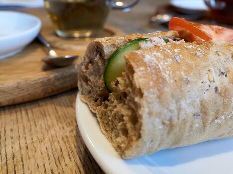 fresh bread snack, detailed view of crusty baguette alongside cucumber slices on rustic table setting photo