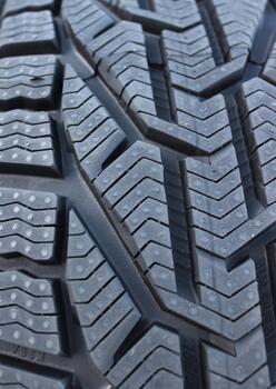 Close Up Photo of New Car Tire Surface with Aggressive Protector Design. Details of Tire Tread Pattern Vertical Photo