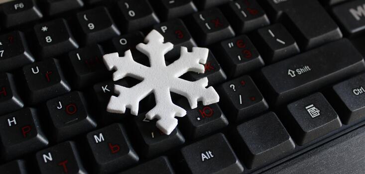 3D Printed Snowflake Lies On Black Desktop Keyboard. Concept Image for Greeting Card Design for IT Workers photo