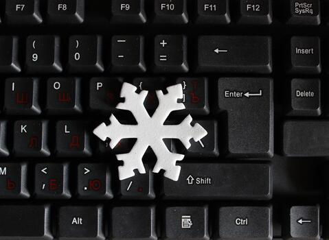 Snowflake Model on Black Computer Keyboard with Red Cyrillic Characters and White Latin Characters. International Holidays Concept Photo