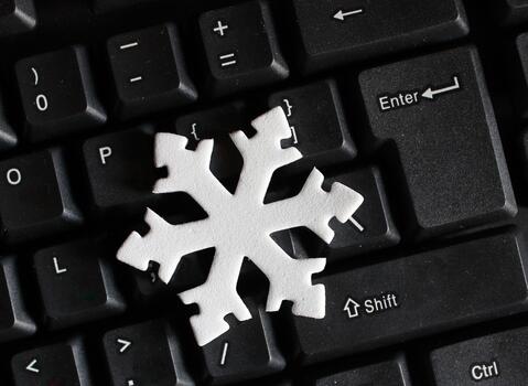 Artificial Snow Sign Near Enter Button on Black Keypad. White Snowflake on a Black Keyboard photo