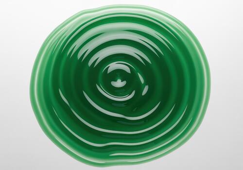 Deep emerald green viscous liquid with concentric ripples creating an abstract fluid pattern photo