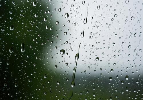 Mesmerizing close up of clear raindrops clinging to a windowpane surface photo