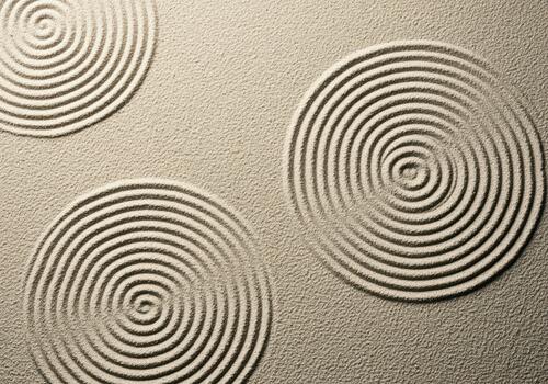 Mesmerizing circular patterns raked into sand in a tranquil zen garden photo