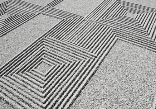 Elegant raked gravel surface with precise geometric square and line designs photo