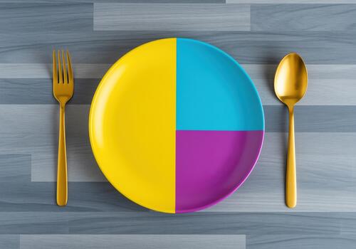 Colorful segmented plate with golden fork and spoon for balanced diet concept photo