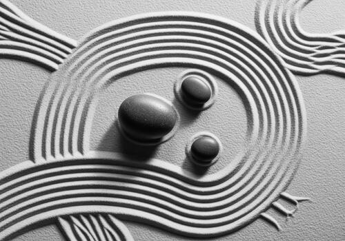 Serene zen garden featuring raked sand patterns and three smooth stones photo