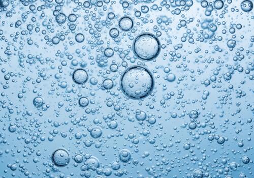 Close up of clear effervescent bubbles in sparkling blue water photo