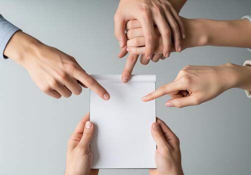 Multiple hands pointing at a blank notepad, symbolizing collaboration and shared ideas photo