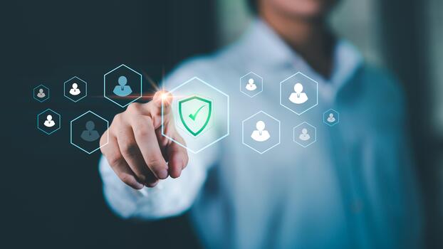 Businessman interacting with a digital interface showing user icons and a security shield, representing workplace safety, employee data protection, secure management systems in modern organizations. photo