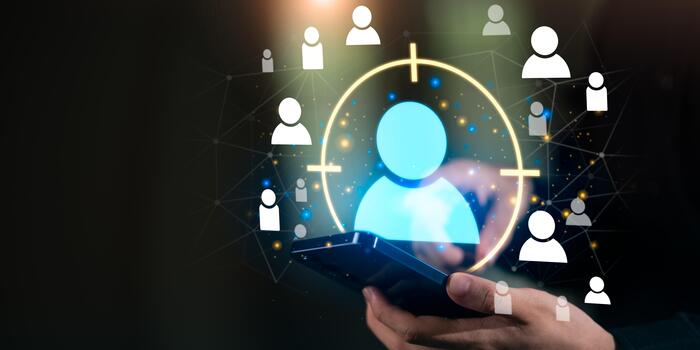 A digital customer targeting concept shows a highlighted user icon above a smartphone, surrounded by audience symbols and network connections, representing data-driven marketing, segmentation photo