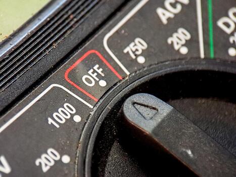 Macro image of a voltmeter showing the power switch in the off position with clear numbering. photo