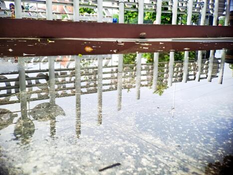 Abstract architectural reflection in water on a paved surface creating a unique visual texture. photo