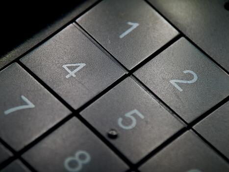 Textured gray keypad displaying numerical values with contrasting white font in an isometric view. photo