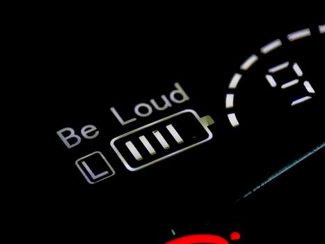 An illuminated display reads 'Be Loud' with a battery icon indicating high power levels in darkness. photo