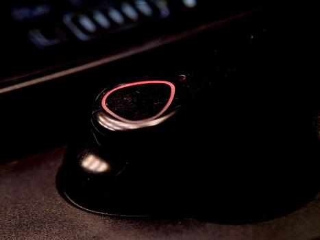 Dark moody background features a button with a red light, implying technology and ambiance. photo