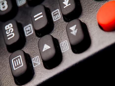 Macro shot featuring the details and symbols on a modern remote control device button surface. photo