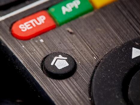 Macro shot of a dusty remote control, showcasing function buttons in a close-up view. photo