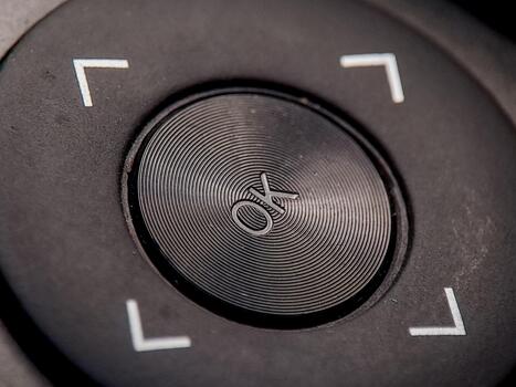 Macro image reveals textured navigation button with direction symbols and concentric circles. photo