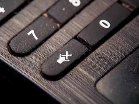 Textured calculator keys featuring numbers seven and zero, with a mute symbol button. photo