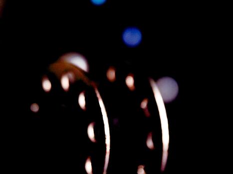 Abstract dark composition with glowing crescent shapes against a hazy, gradient-lit backdrop. photo