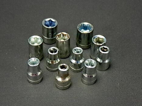 Eleven socket tools are precisely aligned, showcasing a selection of various socket sizes. photo