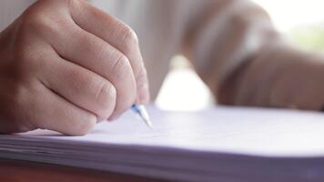 Close-up of a hand writing on paper, representing work, study, note-taking, focus, and productivity in a realistic and concentrated setting video