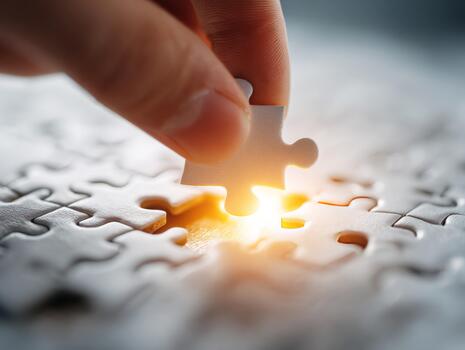 Hand connecting last puzzle piece to complete solution photo