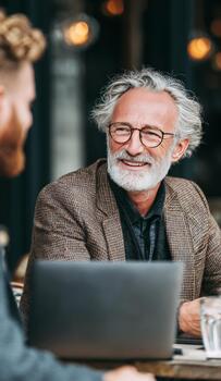 Senior businessman smiling during informal meeting with colleague photo