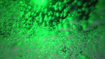 caotico movimento di verde bolle nel piscina acqua con multicolore luci. astratto colorato sfondo video