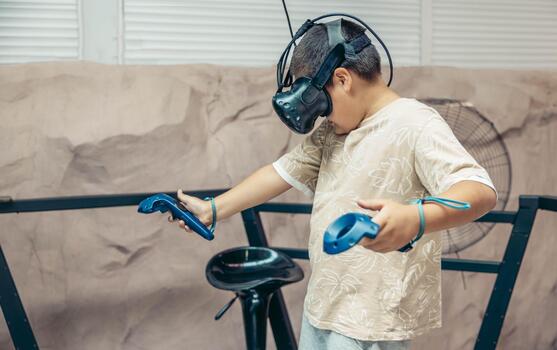 boy wearing a virtual reality headset holds controllers in a gaming setup. The environment is modern and tech-focused, showcasing future gaming technology. photo