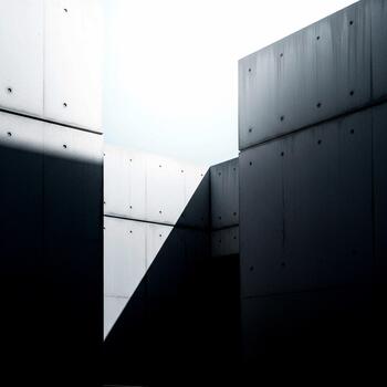 Abstract architectural study of stark concrete forms and dramatic shadows creating a minimalist modern aesthetic with a bright sky photo