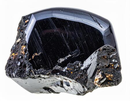 Black shiny rough mineral stone with smooth polished surface and textured edges, displaying natural patterns and reflective qualities in high detail photo