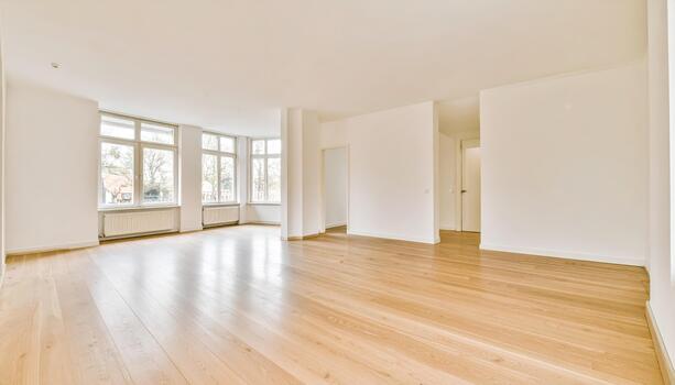 Spacious empty room with large windows and wooden flooring, creating bright and airy atmosphere. white walls enhance natural light, making space feel open and inviting photo