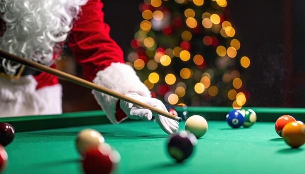 Santa Claus enjoys cheerful holiday game of pool on green billiard table. His hand holds cue stick, aiming at colorful billiard ball with focused concentration, creating joyful festive atmosphere photo